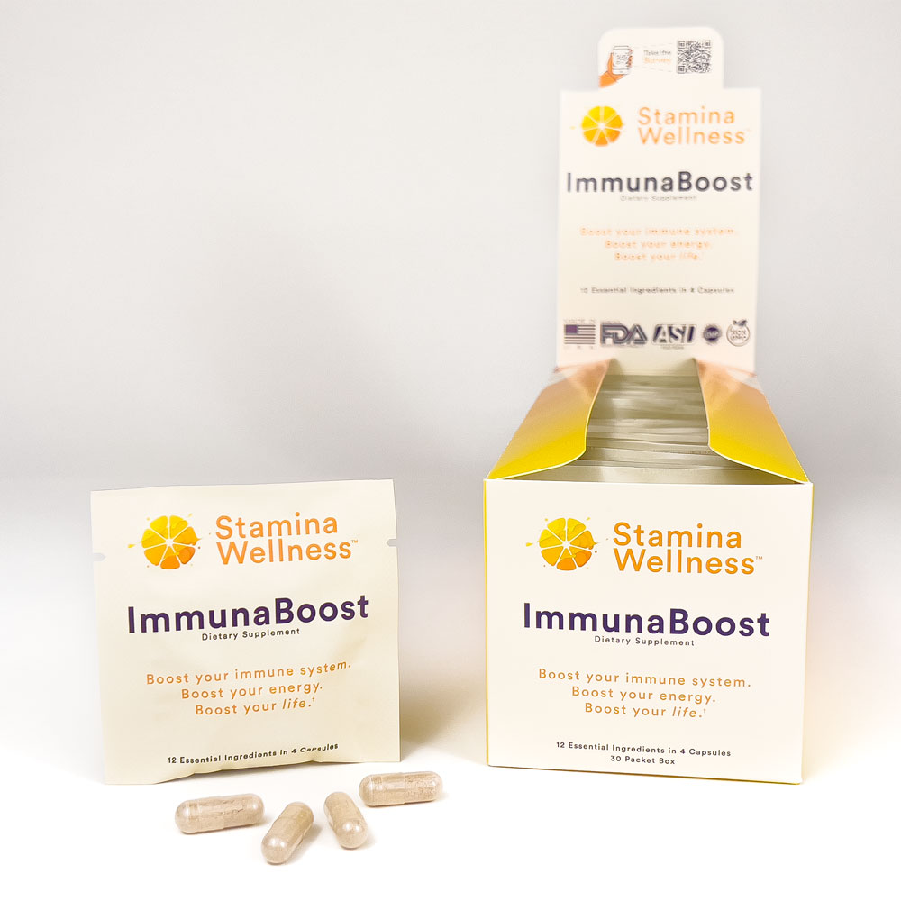 Four capsules of ImmunaBoost sitting in front of a packet of ImmunaBoost next to a box of ImmunaBoost